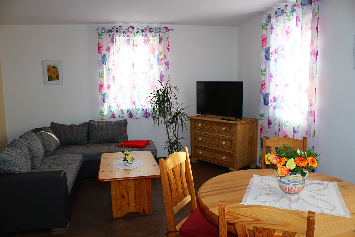 Ferienwohnung Billy in Weißig - Wohnung "Bärenstein" - Wohnzimmer mit Sofa, TV und Esstisch